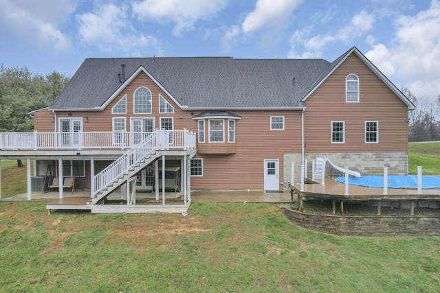 back of house featuring a lawn and a deck