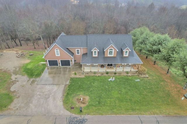 view of front of home featuring covered porch, a front yard, and a garage