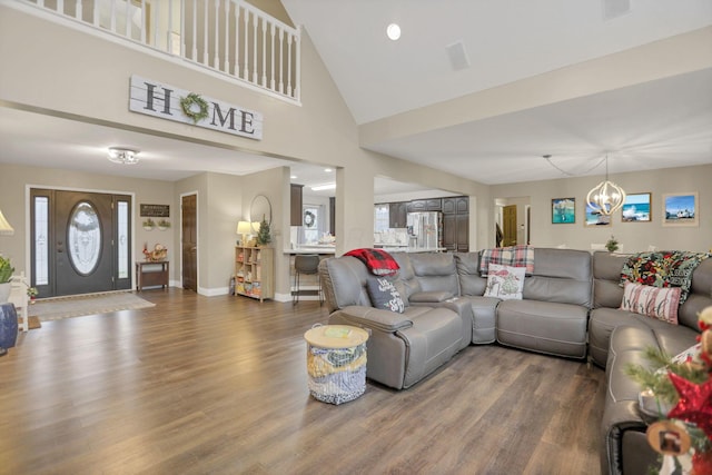 living room with dark hardwood / wood-style floors, high vaulted ceiling, a wealth of natural light, and a notable chandelier