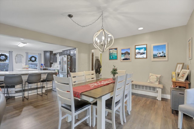 dining area with an inviting chandelier and dark hardwood / wood-style flooring