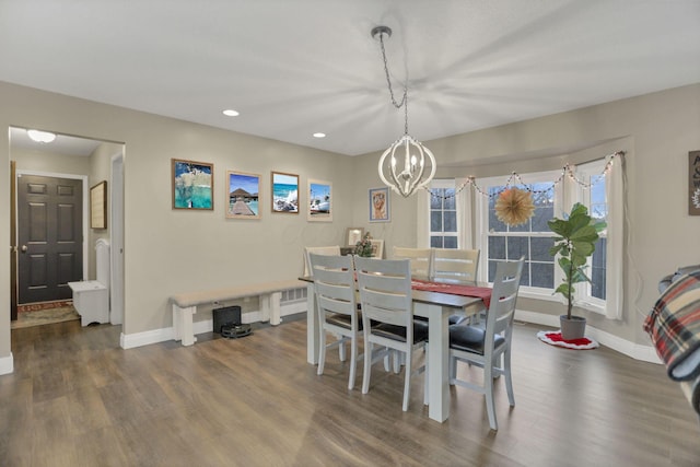 dining space with dark hardwood / wood-style floors and an inviting chandelier