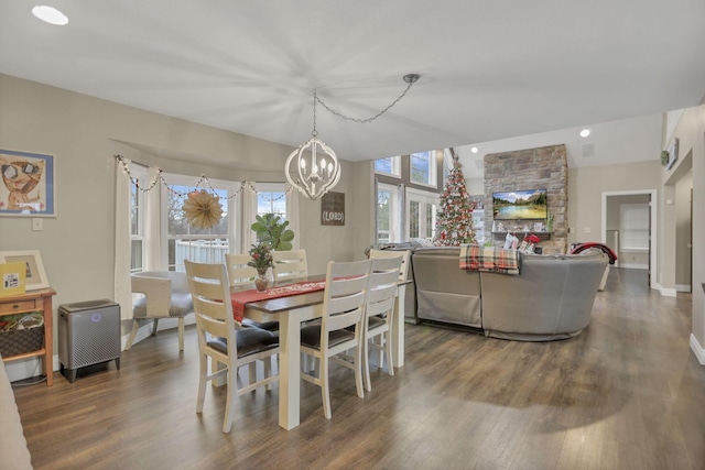 dining area featuring vaulted ceiling, a chandelier, and dark hardwood / wood-style flooring