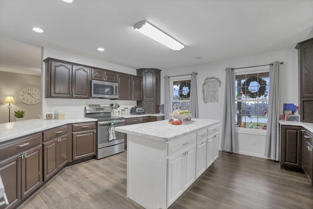 kitchen with decorative backsplash, light hardwood / wood-style floors, dark brown cabinetry, and appliances with stainless steel finishes