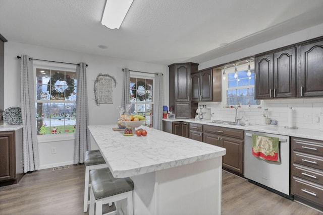 kitchen featuring dishwasher, dark hardwood / wood-style floors, a healthy amount of sunlight, and sink