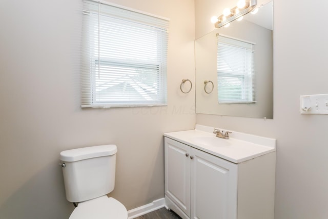 bathroom featuring vanity, a healthy amount of sunlight, and toilet