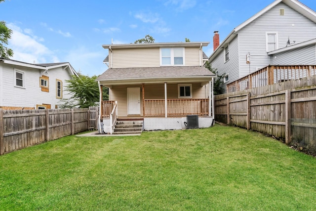 rear view of house featuring central AC unit and a yard