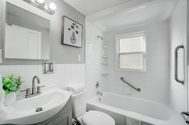 full bathroom with tiled shower / bath combo, tasteful backsplash, toilet, vanity, and tile walls