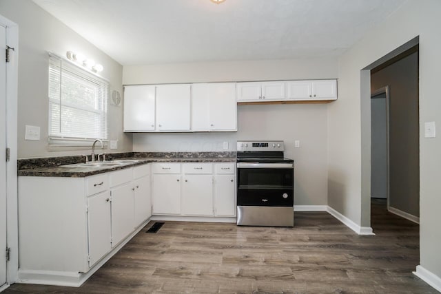 kitchen featuring stainless steel electric stove, white cabinetry, sink, and hardwood / wood-style floors