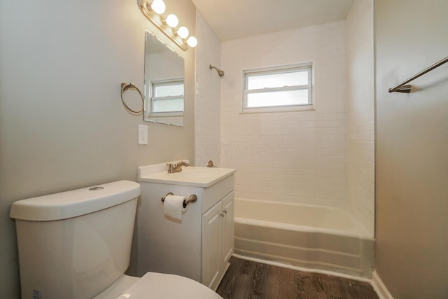 full bathroom with tiled shower / bath, hardwood / wood-style floors, vanity, and toilet