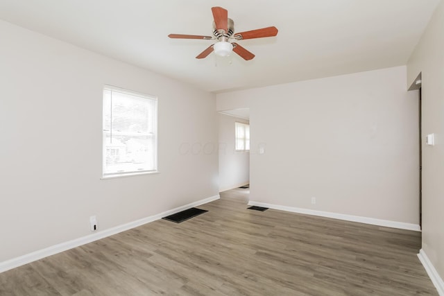 spare room with hardwood / wood-style floors, ceiling fan, and a wealth of natural light