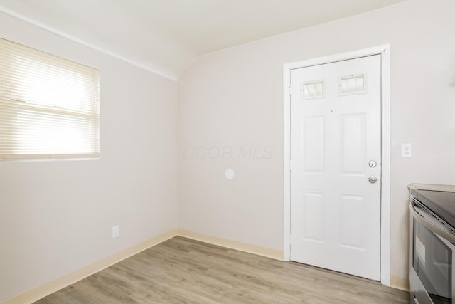 empty room featuring light hardwood / wood-style floors and vaulted ceiling