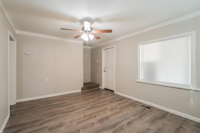 unfurnished room featuring crown molding, hardwood / wood-style floors, and ceiling fan