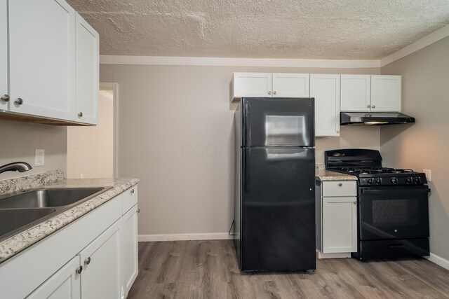 kitchen with black appliances, light hardwood / wood-style floors, white cabinetry, and crown molding