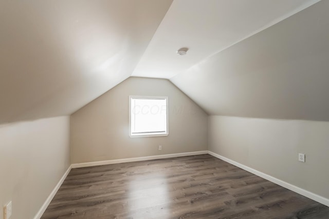 additional living space featuring lofted ceiling and dark wood-type flooring