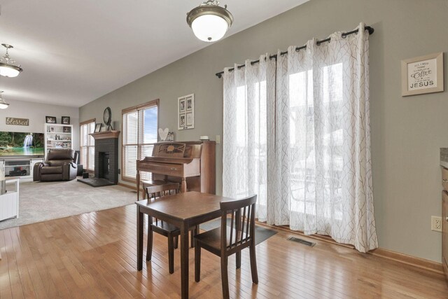 dining area featuring a fireplace and light hardwood / wood-style floors