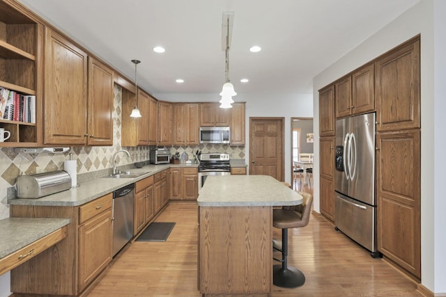 kitchen featuring sink, a kitchen island, pendant lighting, and appliances with stainless steel finishes