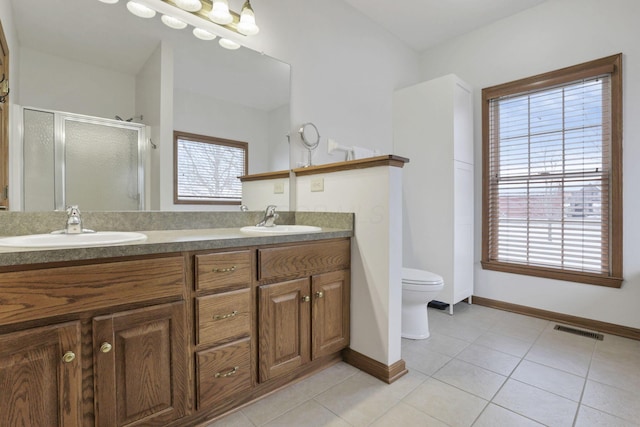 bathroom featuring toilet, vanity, tile patterned floors, and walk in shower