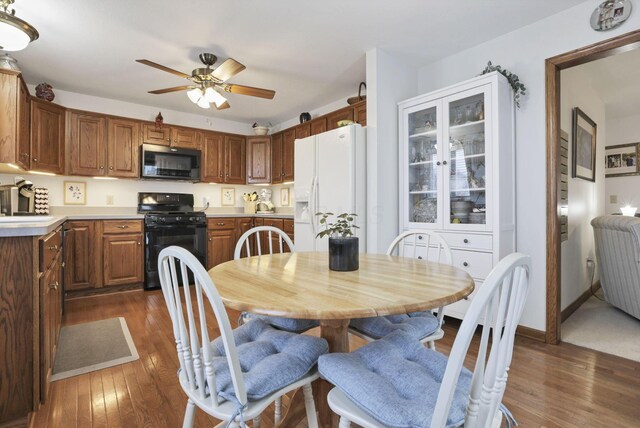 kitchen featuring black appliances, ceiling fan, and dark hardwood / wood-style flooring