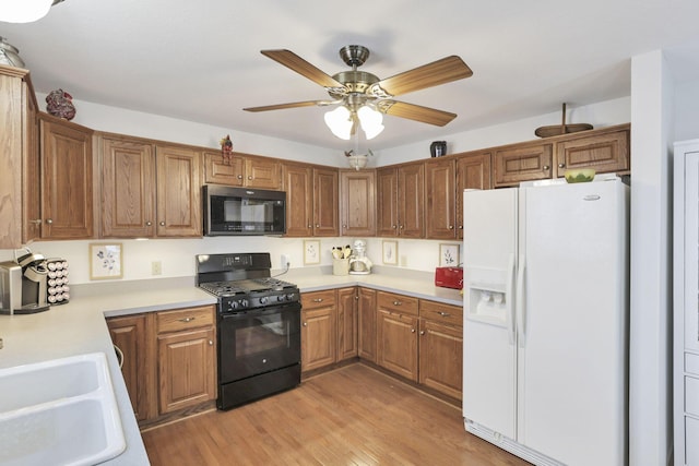 kitchen featuring ceiling fan, sink, black appliances, and light hardwood / wood-style floors