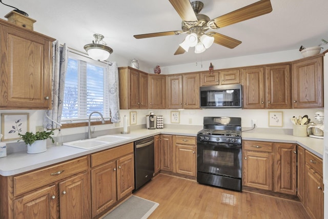 kitchen with light wood-type flooring, stainless steel dishwasher, gas stove, ceiling fan, and sink