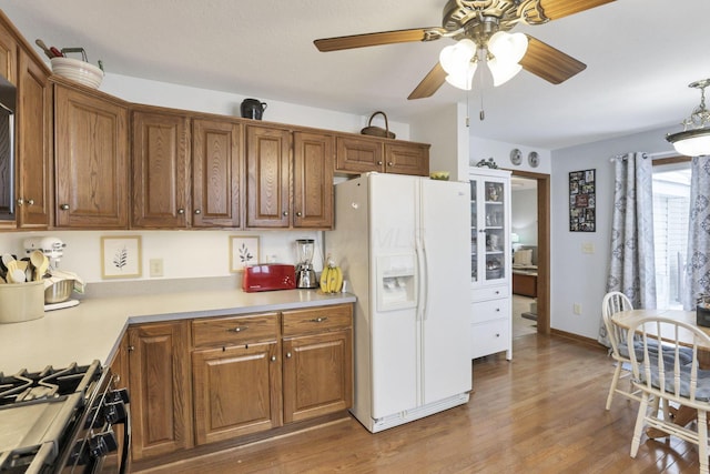 kitchen featuring range with gas cooktop, ceiling fan, white refrigerator with ice dispenser, and light hardwood / wood-style flooring