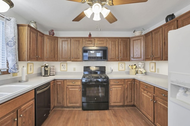 kitchen featuring black appliances, ceiling fan, light hardwood / wood-style floors, and sink