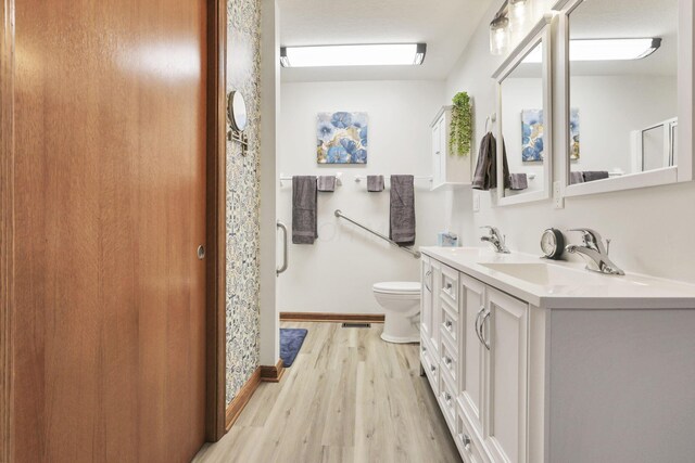 bathroom featuring toilet, vanity, and hardwood / wood-style flooring