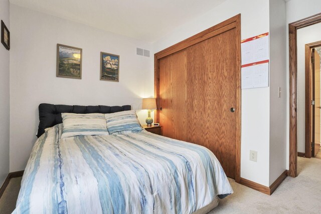 bedroom featuring light colored carpet and a closet