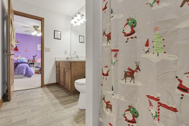 bathroom featuring vanity, curtained shower, toilet, and ceiling fan