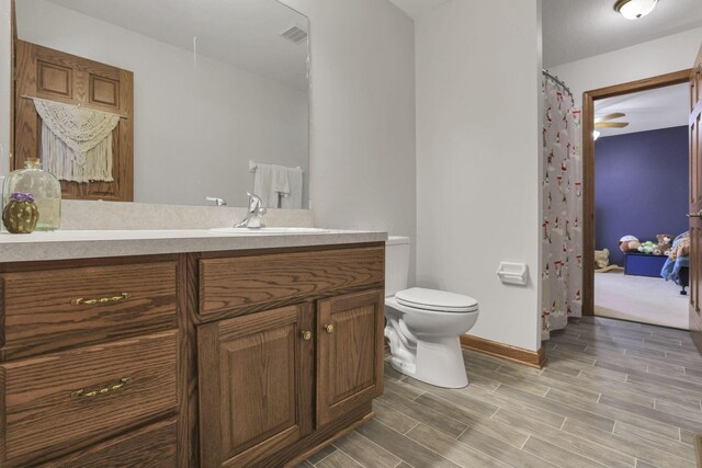 bathroom featuring vanity, toilet, and ceiling fan