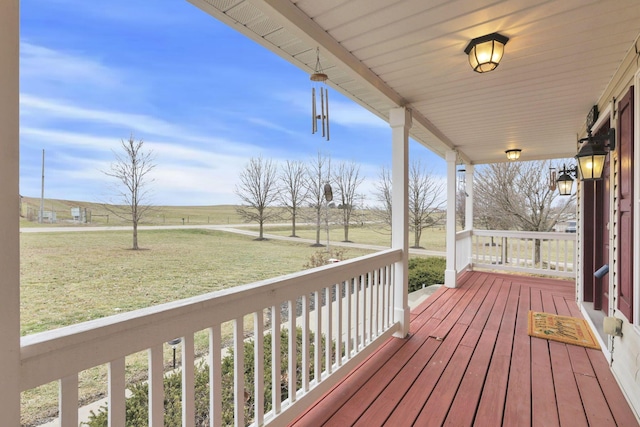 deck featuring a porch, a yard, and a rural view