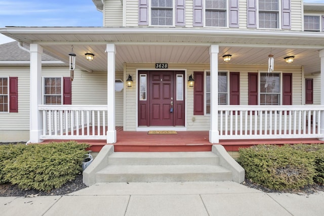 view of exterior entry featuring covered porch