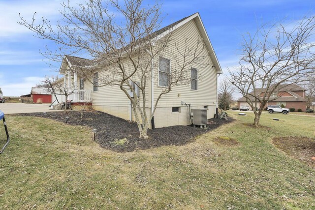 view of home's exterior with cooling unit and a yard