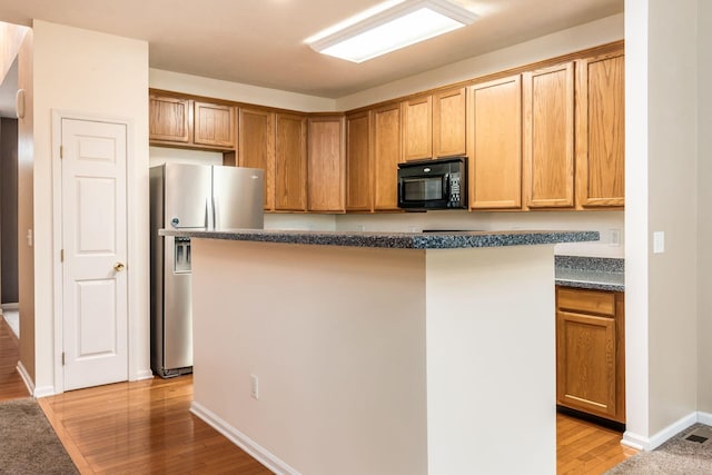 kitchen featuring a kitchen island, stainless steel fridge with ice dispenser, and light hardwood / wood-style flooring