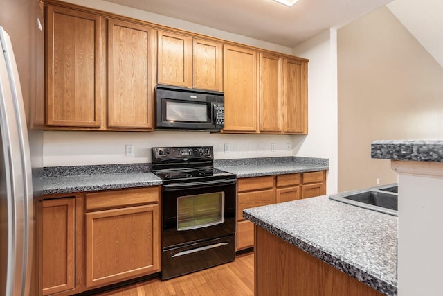 kitchen featuring black appliances, light hardwood / wood-style floors, and sink