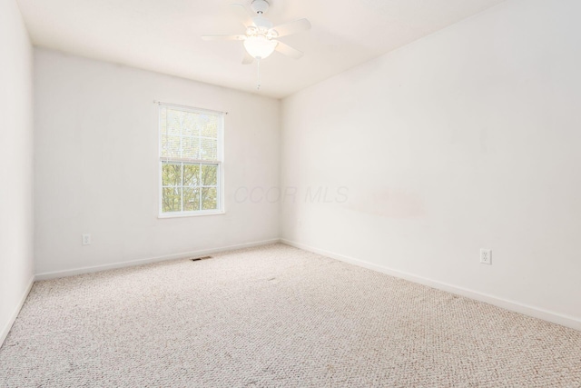 carpeted spare room featuring ceiling fan