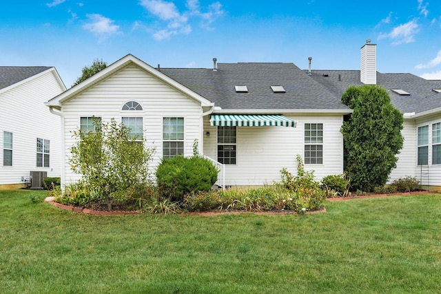 rear view of house with a yard and cooling unit