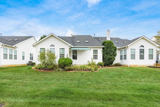 back of house featuring central AC and a lawn