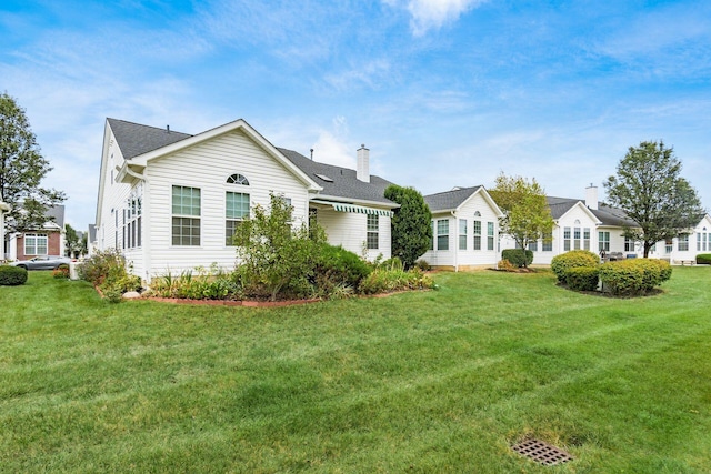 rear view of property featuring a yard