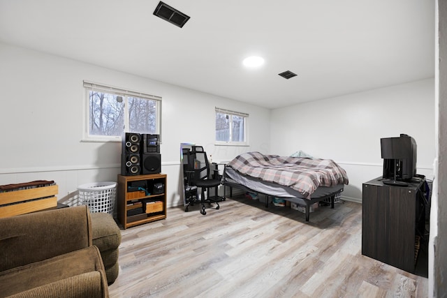 bedroom with light hardwood / wood-style floors and multiple windows