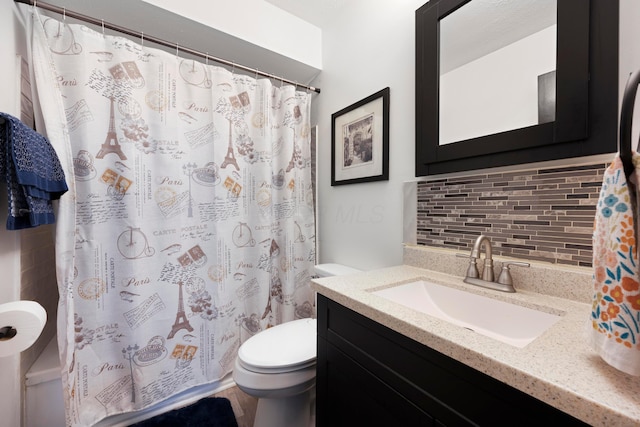 bathroom with vanity, toilet, backsplash, and walk in shower