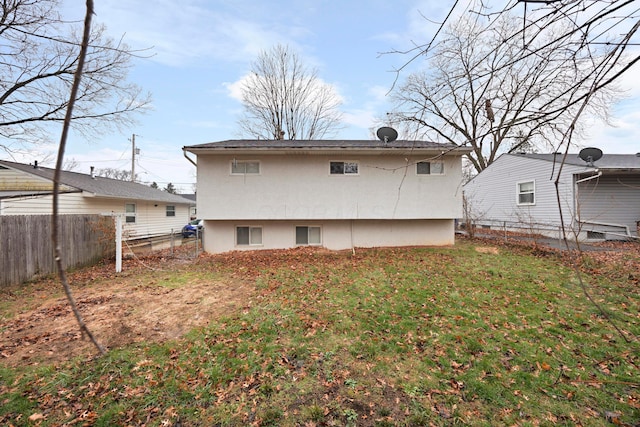 rear view of property featuring a lawn