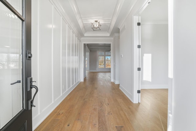 hallway featuring light wood-type flooring, baseboards, visible vents, and crown molding