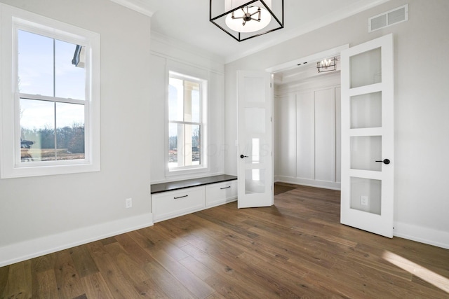 interior space featuring a notable chandelier, visible vents, baseboards, dark wood-style floors, and crown molding