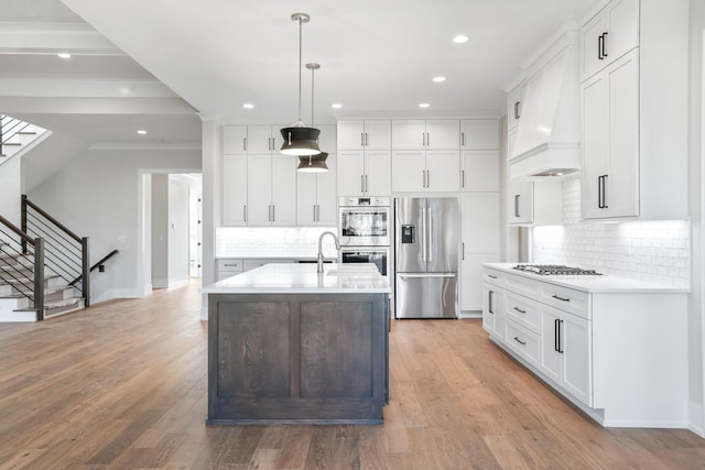 kitchen featuring white cabinets, stainless steel appliances, light countertops, and decorative light fixtures