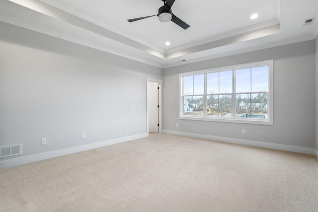 unfurnished room with a raised ceiling, visible vents, and baseboards