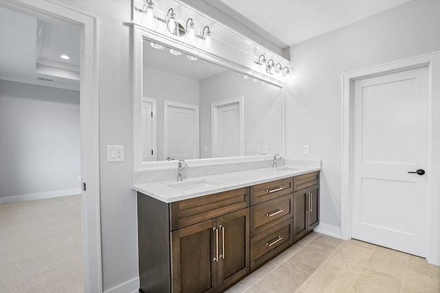 bathroom with double vanity, recessed lighting, a sink, and baseboards