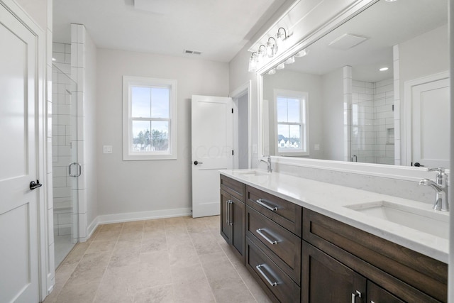 bathroom with a stall shower, visible vents, and a sink