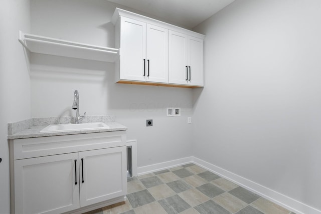 washroom featuring cabinet space, baseboards, a sink, hookup for a washing machine, and electric dryer hookup