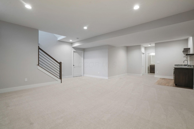 finished basement featuring recessed lighting, light carpet, baseboards, and stairs